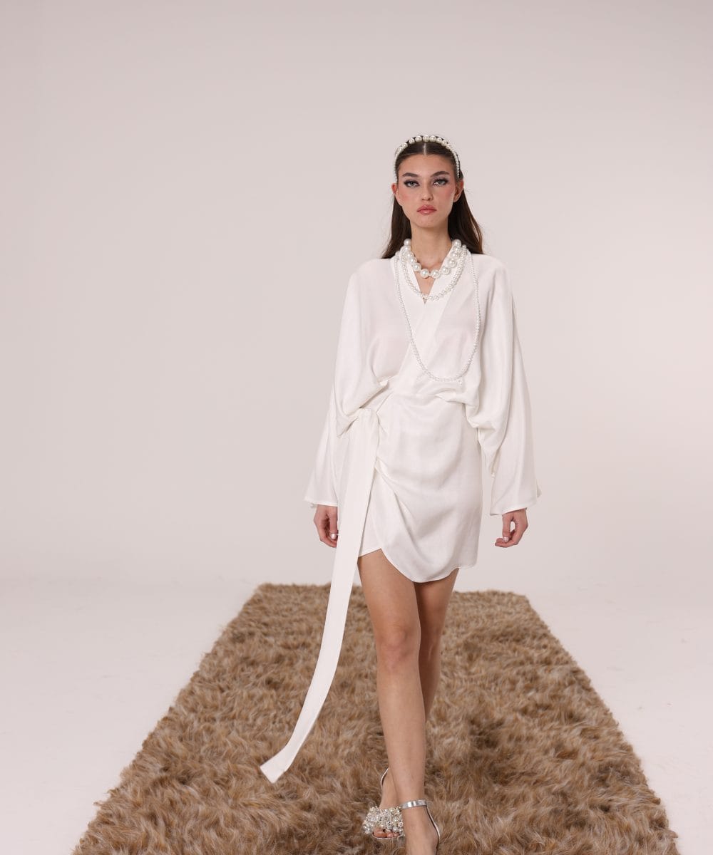 Akışkan ipek keten kumaşıyla hareket eden drapeli beyaz mini elbise