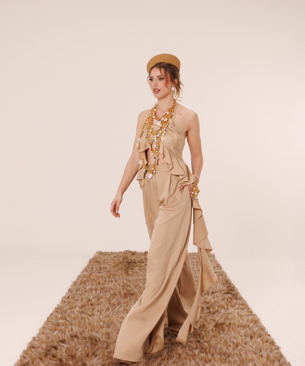 Bej renkli ipek-keten karışımı kumaştan yapılmış, sırt dekolteli ve volanlı pantolon detaylı Soul of Leila Sahara Sands lüks takım yürüyüş pozu